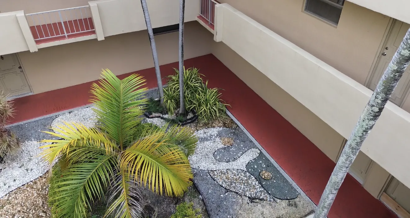 Landscaped courtyard with palm trees and residential walkways at Casa Real